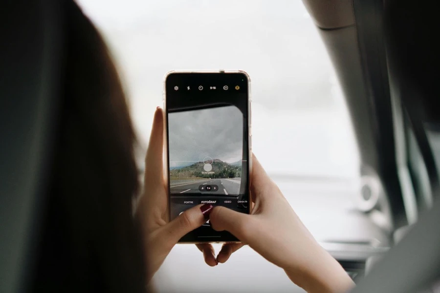 車の写真をスマートフォンで撮影する場面