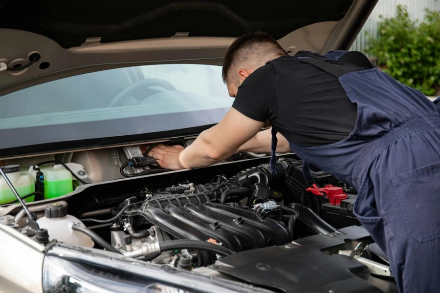 純正パーツや整備記録簿を車の前に並べて整理している場面