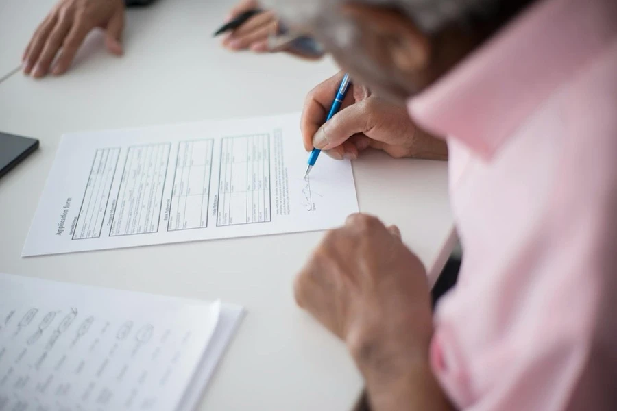 相続書類と車検証をテーブルに広げて確認している場面