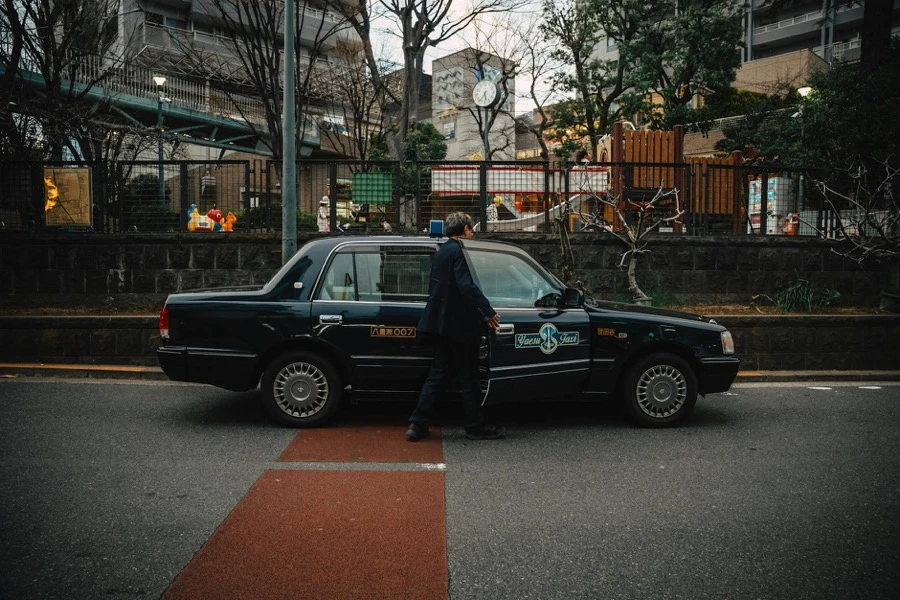車検切れの車を前に売却を検討する男性のイメージ
